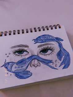 a drawing of a woman's face with blue hair and fish around her eyes