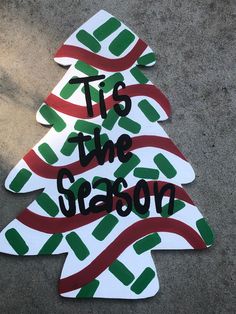 a christmas tree made out of cardboard with the words tis the season painted on it