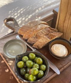 olives, bread and butter are on a tray