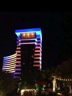 the hotel is lit up at night with colorful lights