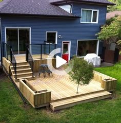 a blue house with steps leading up to the front door and deck area in the yard