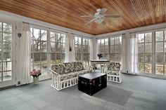 a living room with wood ceiling and white furniture