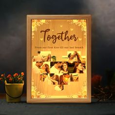 a wooden photo frame with the words together on it next to a potted plant