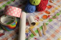 yarn, crochet hooks, and tape on a table with other crafting supplies