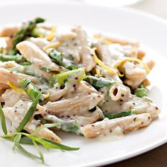 a white plate topped with pasta and asparagus