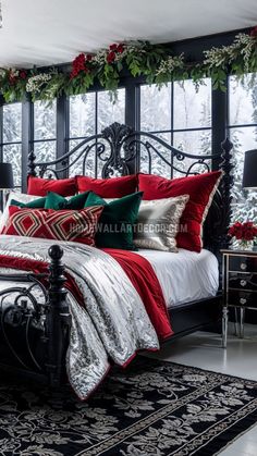 a black bed with red and green pillows on top of it in a room decorated for christmas