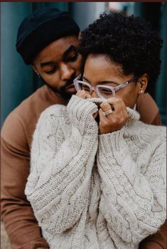 a man and woman in sweaters holding each other