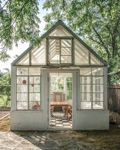 a small white house sitting in the middle of a yard