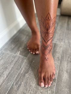 a woman's bare feet with a tattoo on her lower leg and bottom part