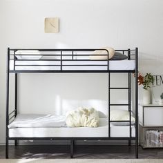 a black bunk bed with white sheets and pillows on top of it in a room