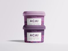 two ice cream containers sitting next to each other on a white surface with the words acai printed on them