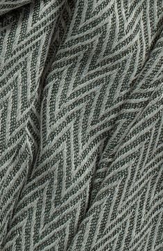 closeup of the texture of a knitted sweater in grey and white colors, as seen from above