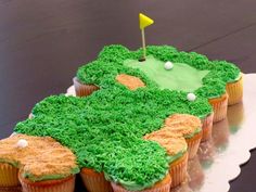 a cake shaped like a golf course with cupcakes