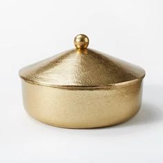 a gold covered dish sitting on top of a white table