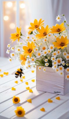 a vase filled with yellow and white flowers on top of a table next to a bee