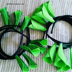 two green and black hair bows on top of a white cloth covered table with text overlay that says, how to make your own dragon ears