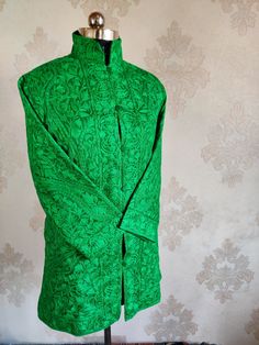 A Pure Silk Monochromatic Green Kashmiri Jacket with All Over Heavy Aarii Embroidery (Front & Back) This Kashmiri jacket Makes you stand apart with its vivid colors and paisley embroidery, The base colour is Green and the embroidery is done by brilliant Kashmiri artisans. Fabric : Pure Raw Silk Embroidery : Aari Length : 35 Inches [Customizable] Colour : Green Free Shipping : Yes Lining : Fully Lined *If you want the Length , Arms of the jacket to be customized , Drop us a message, and we will m Bollywood Style Long Sleeve Outerwear For Eid, Designer Embroidered Green Sherwani, Traditional Outerwear With Zari Work For Eid, Traditional Outerwear With Chikankari Embroidery, Ceremonial Outerwear With Zari Work For Eid, Fitted Designer Outerwear With Zari Work, Traditional Formal Bandhgala With Embroidered Border, Traditional Fitted Outerwear With Traditional Drape, Elegant Bandhgala With Embroidered Border For Festivals