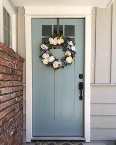 a blue front door with a wreath on it