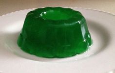 a green jello sitting on top of a white plate