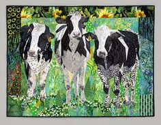 three black and white cows standing next to each other on a green field with sunflowers