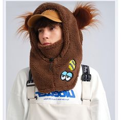 a person wearing a hat and scarf with a furry animal on it's head