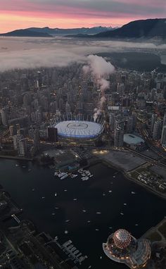 an aerial view of the olympic stadium in vancouver, canada at sunset with fog and low lying clouds