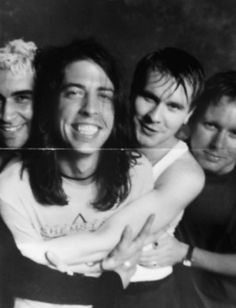 four young men are posing together for a black - and - white photo with one holding the other's arm around his neck