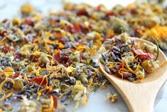 a wooden spoon filled with dried flowers on top of a table