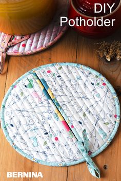 a wooden table topped with a plate covered in paper and two crochet hooks