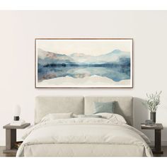 a painting hanging above a bed in a room with a white comforter and pillows