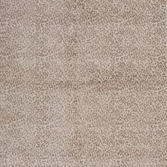 an animal print area rug with white and brown spots on the top, in front of a beige background