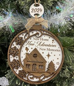 Our New Home Christmas Ornament is the perfect keepsake for anyone on your Christmas list who has recently purchased a new home, moved into a new apartment, or is moving to a new location. It is a handmade, laser cut, multi-layered, rustic wooden ornament that will be treasured for years to come. Ornament is 4" x 4" round. All pieces are individually laser cut, hand painted, and hand-assembled in our shop.  The ornament is strung with a jute string hanger, a cute burlap bow, and a wooden tag eng Gift For New Home Owner, New Home Owner, Gift For New Home, Home Owner, Burlap Bow, Home Handmade, Wooden Tags, New Apartment, Burlap Bows