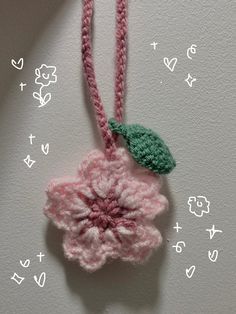 a crocheted flower is hanging from a string