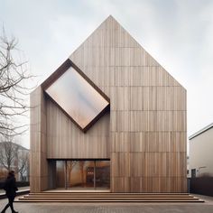 a person walking past a large wooden building