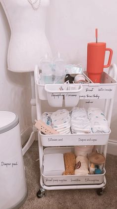 a white cart filled with baby items next to a lamp