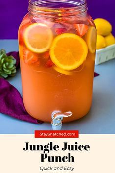 a mason jar filled with orange juice and sliced lemons on top of a table