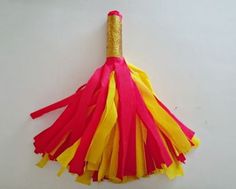 a red, yellow and pink tassel hanging from a white wall