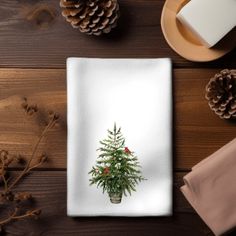 a christmas tree on a napkin next to pine cones