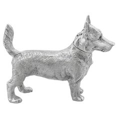 a silver dog figurine is standing on a white background and looks to the side