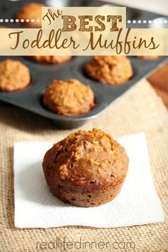 a muffin sitting on top of a white napkin next to a muffin tin