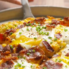 a close up of a pizza on a pan with cheese and meats in it