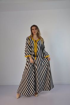 This beautiful striped dress with a dash of gold embroidery Kaftan is a touch of class and elegance to your wardrobe. With the gold embroidery and the extremely soft Egyptian cotton, it is an extremely comfortable wear. You can wear this dress anywhere, in parties, gatherings, home, indoors, outdoors.Material : 80% Egyptian Cotton and 20% PolyesterMeasurements : Free size. Fits nicely from a Size small to an 2XL. It takes the shape of any body.**Please note that shipping to these locations in th Long Embroidered Free-size Kaftan, Festive Maxi-length Black Kaftan, Elegant Black Embroidered Kaftan, Embroidery Kaftan, Bohemian Black Floor-length Kaftan, Silk Kimono Dress, Black Flowy Maxi-length Kaftan, Arabic Dress, Abaya Kimono