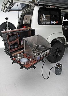 an off - road vehicle is parked in a garage with the hood open and cooking utensils on it