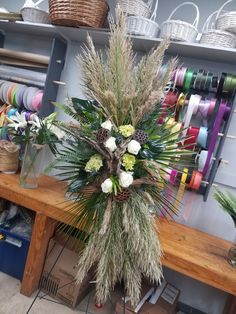 a wooden table topped with lots of different types of flowers