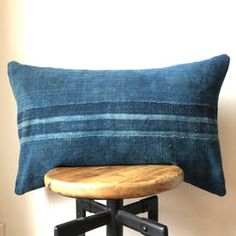 a blue pillow sitting on top of a wooden stool