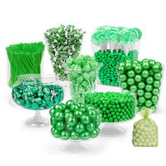 green and white candies in clear glass containers with candy bags on the bottom one