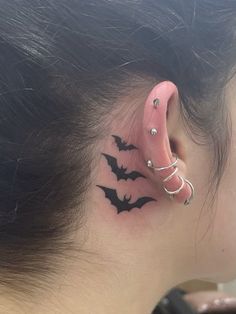 a woman's behind the ear tattoo with bats