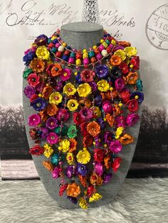 a necklace made out of colorful flowers on a mannequin headdress,