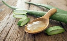 a wooden spoon filled with cucumber slices on top of a table