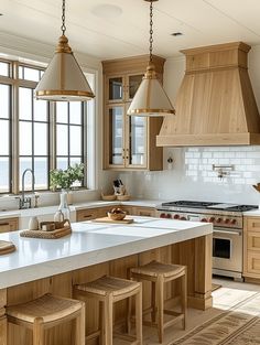 a large kitchen with wooden cabinets and white counter tops, along with stools in front of the island